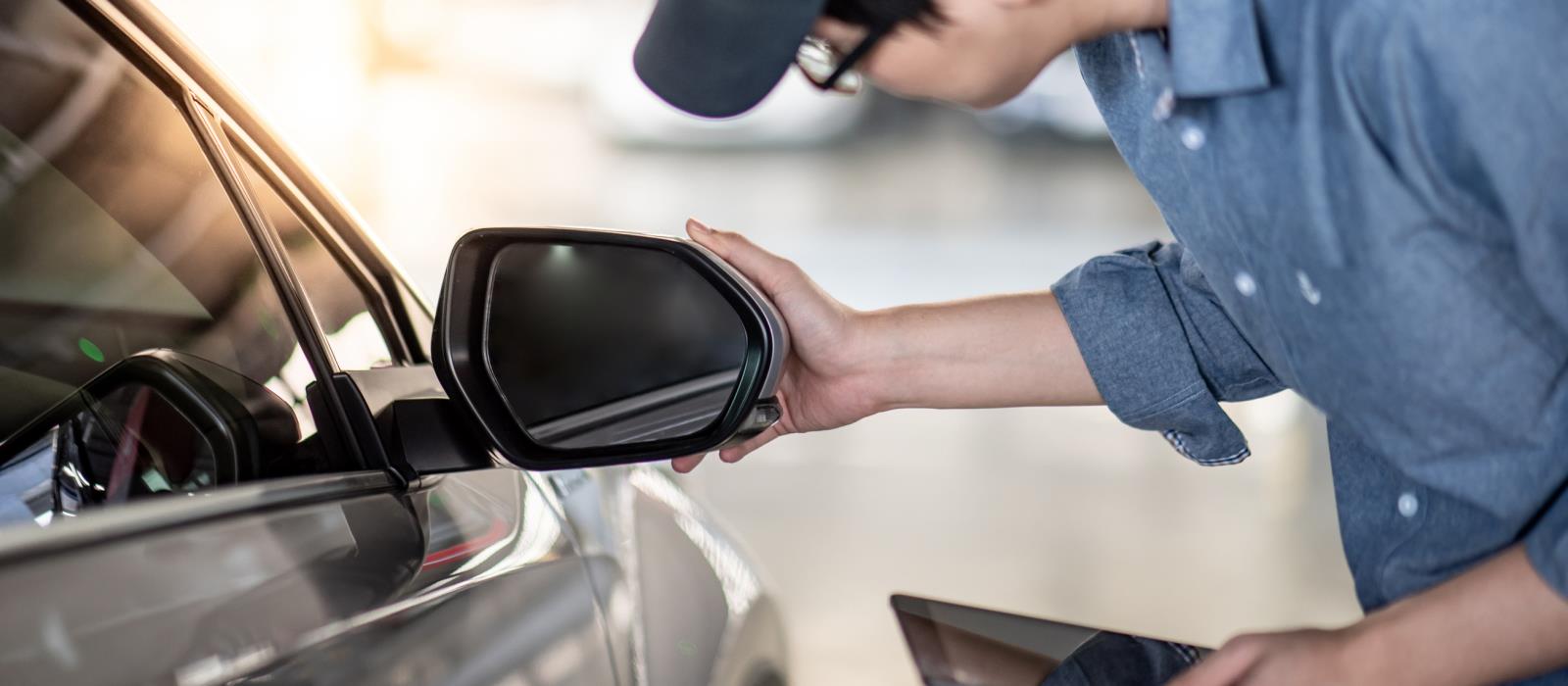 image of service personnel adjusting side view car mirror