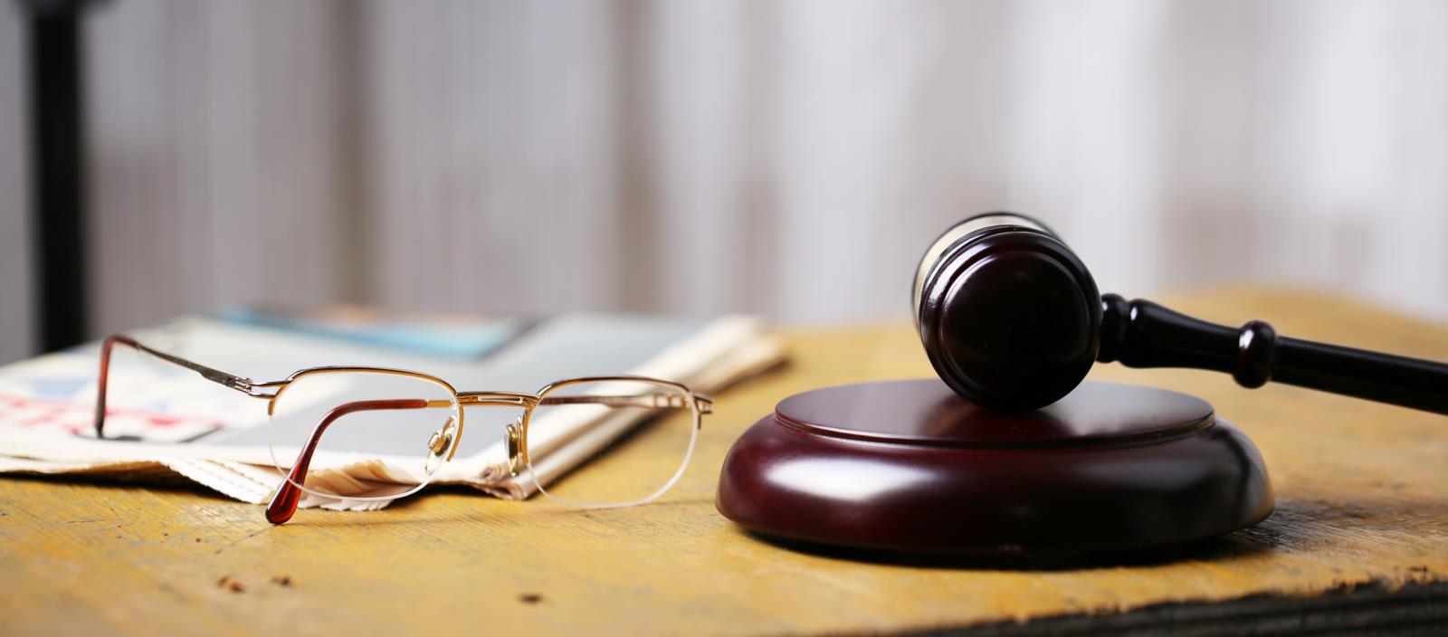 image of gavel book and eye glasses on a table