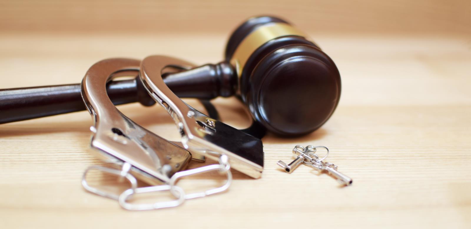 photo of a gavel with handcuffs