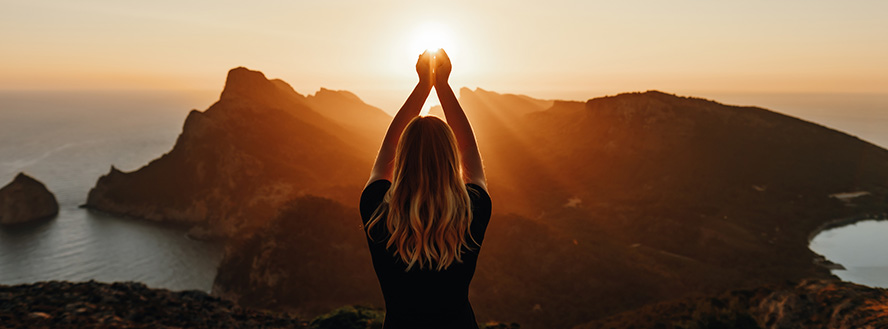 photo of blonde female hands above her head at sunrise