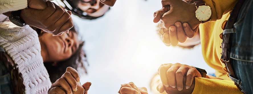 photo of diverse group of people holding hands looking down