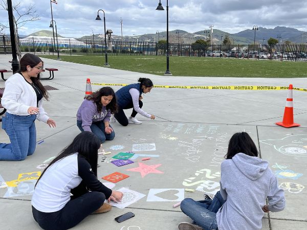 Group of teens drawing with chalk