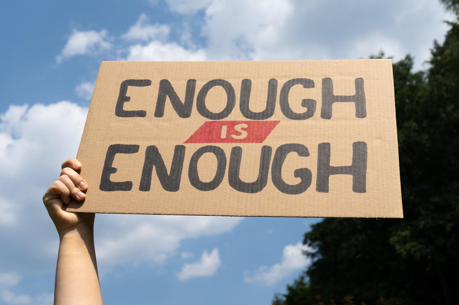 person holding a sign stating enough-is-enough