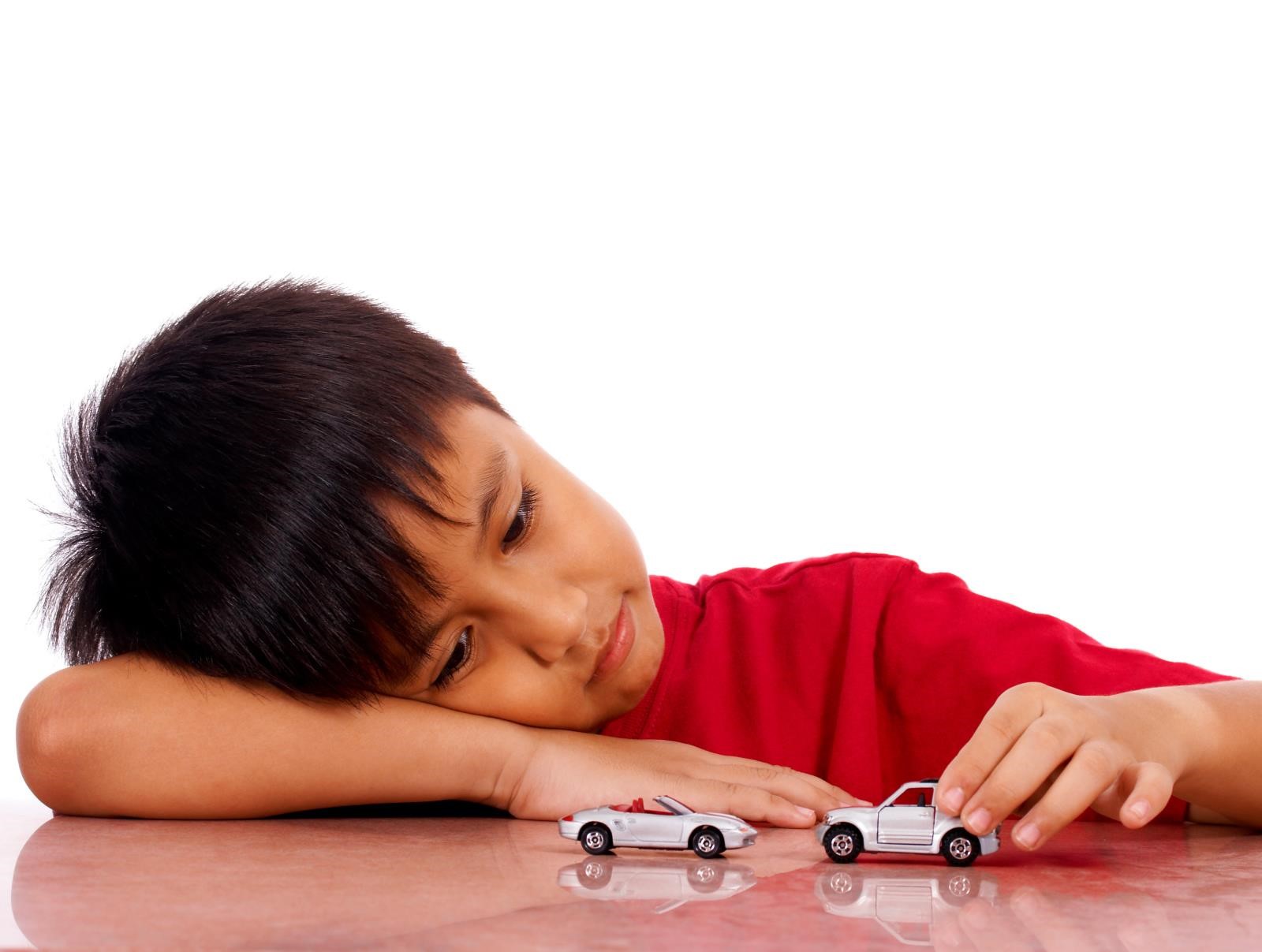 young boy playing with cars