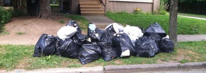 trash bags piled up in front of a house