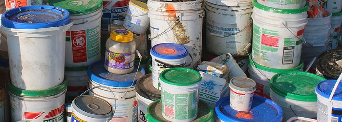 buckets of old paint stacked in a pile